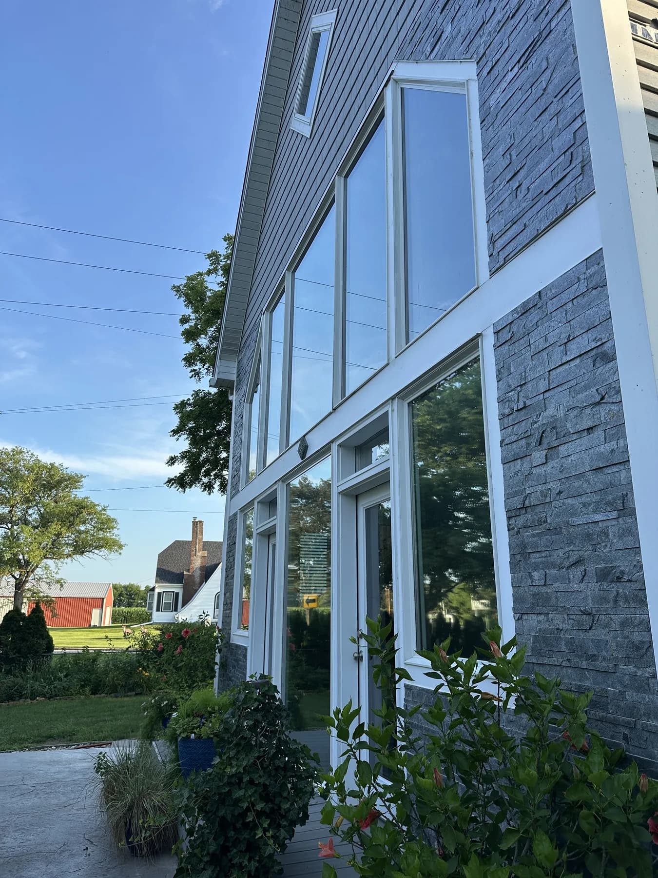 Clear residential windows on a stacked-stone house in Olathe after washing by JB Window Washing