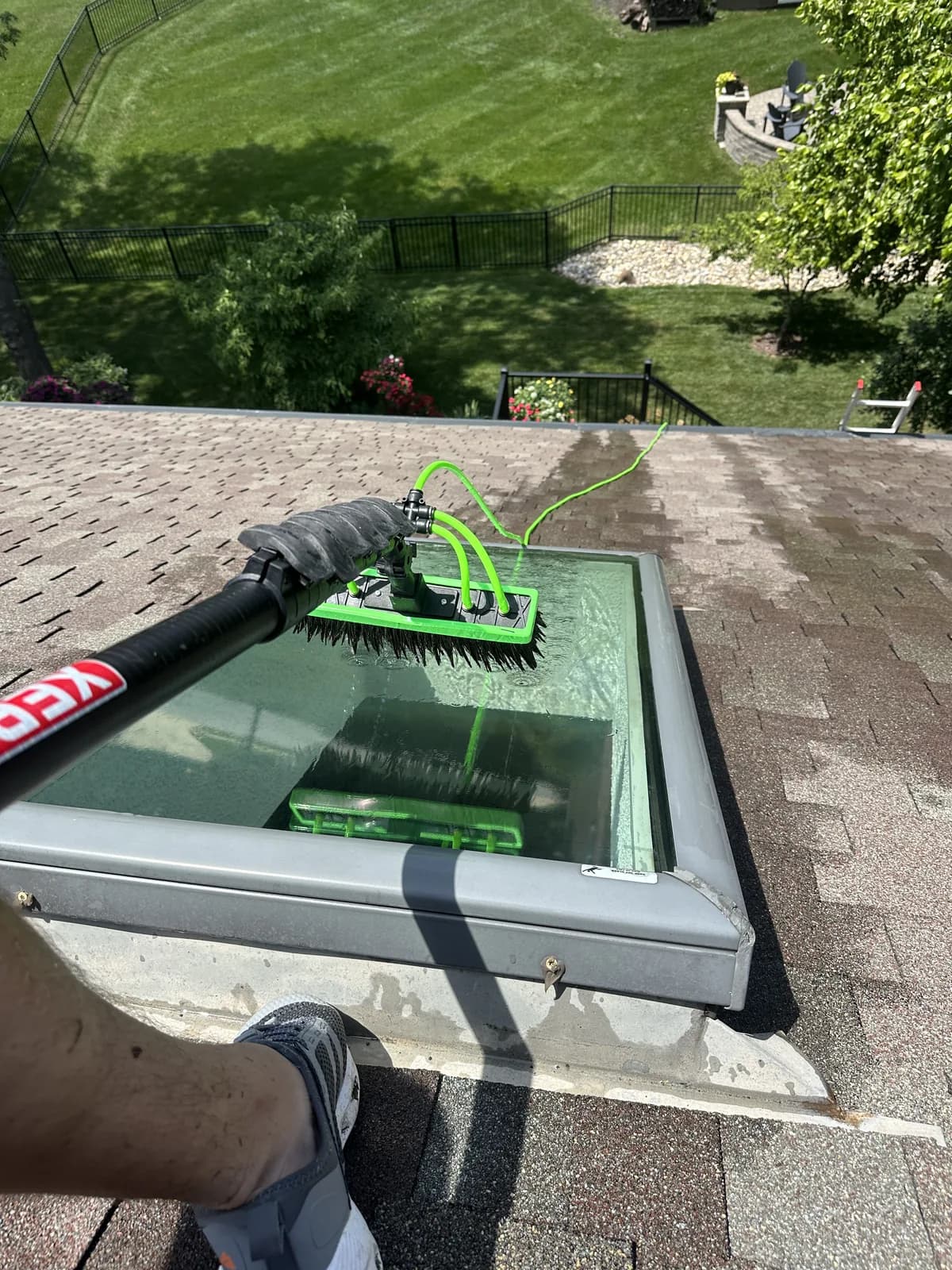 Water-fed pole washing a skylight from the roof line in Olathe