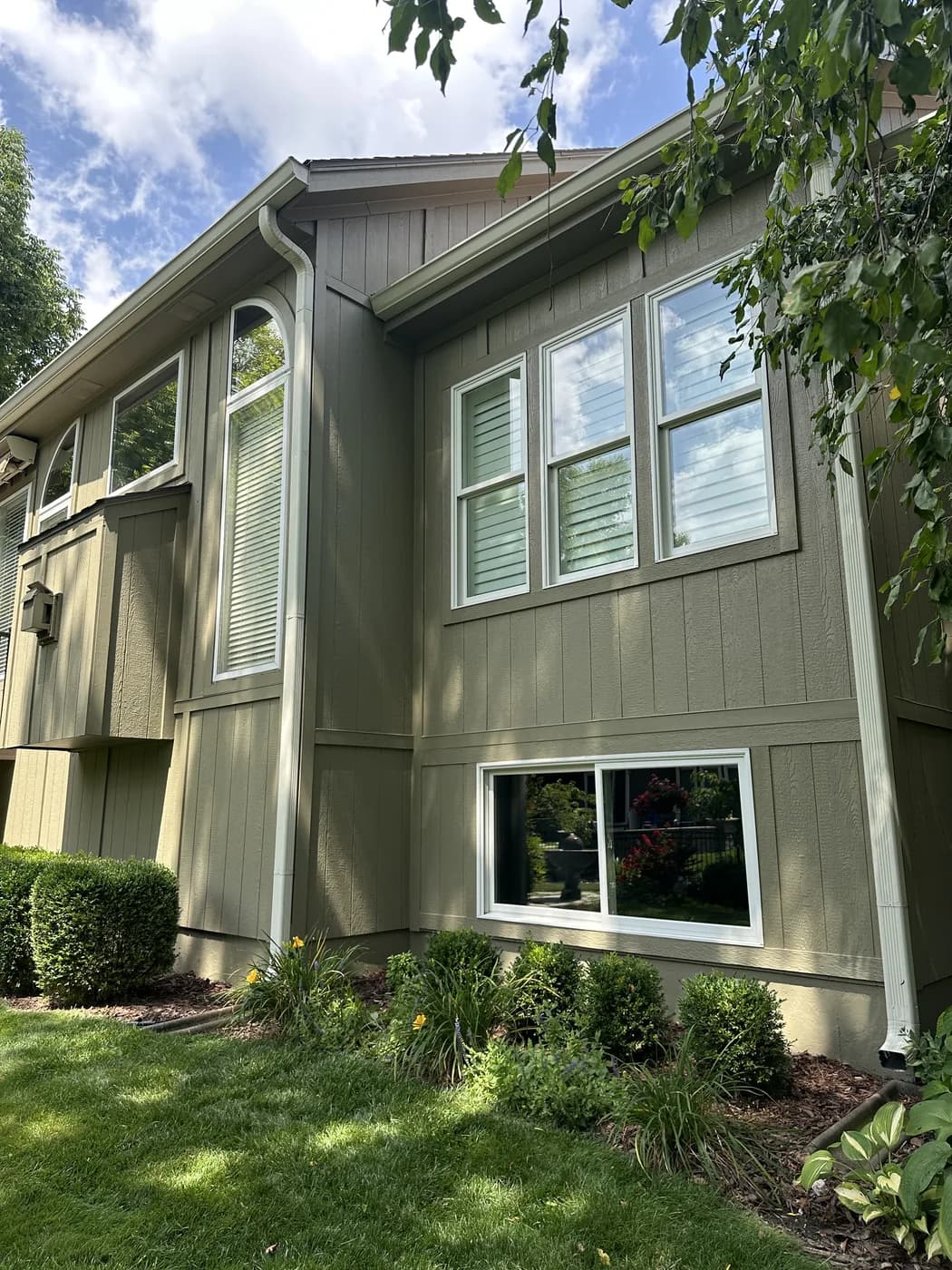 Window cleaning on a two-story sage house in Olathe